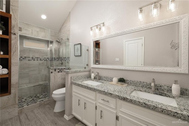 bathroom with a tile shower, vanity, lofted ceiling, and toilet