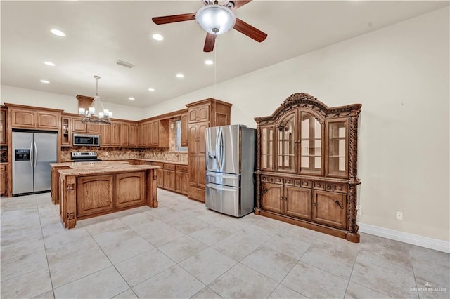 kitchen featuring glass insert cabinets, stainless steel appliances, a center island, brown cabinets, and decorative light fixtures