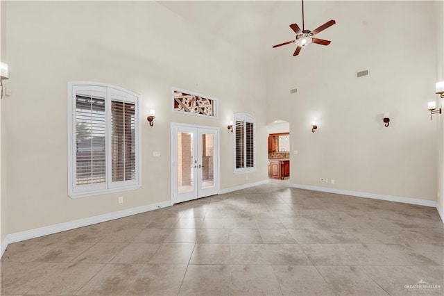 unfurnished living room featuring ceiling fan, french doors, light tile patterned floors, and baseboards