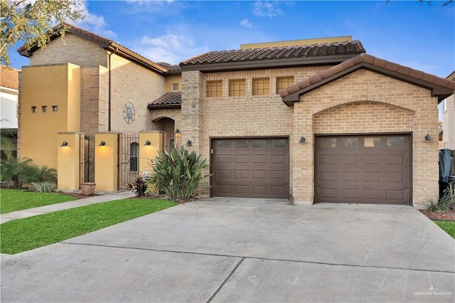 mediterranean / spanish-style house with driveway, a tiled roof, an attached garage, a gate, and brick siding