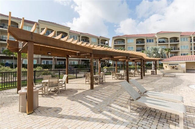 310 E Houston St Unit 1403, Port Isabel, TX 78578 - view of property's community featuring a pergola, fence, a patio area, and outdoor dining space