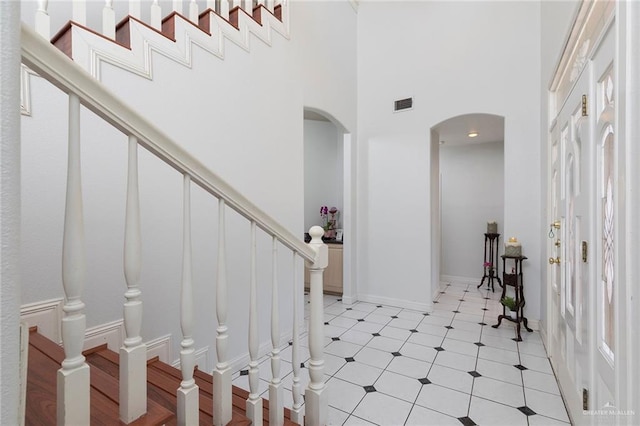 3305 W San Luis Cir, Mission, TX 78573 - entryway featuring arched walkways, a towering ceiling, stairs, light flooring, and baseboards