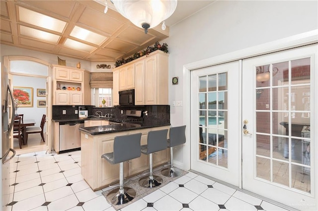 3305 W San Luis Cir, Mission, TX 78573 - kitchen featuring stainless steel appliances, a peninsula, tasteful backsplash, dark countertops, and a breakfast bar area