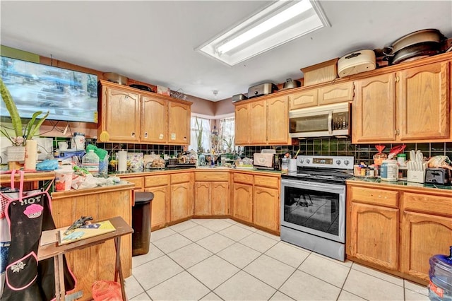 kitchen featuring light tile patterned floors, stainless steel appliances, and decorative backsplash