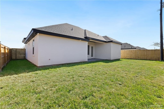 rear view of property featuring a lawn