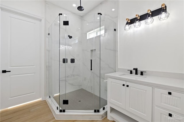 bathroom with wood-type flooring, vanity, and walk in shower