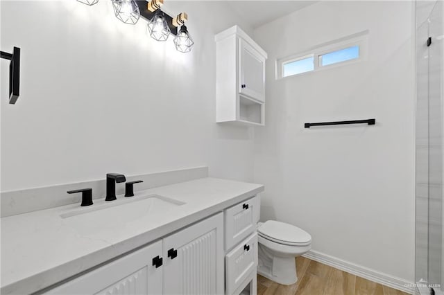 bathroom featuring toilet, wood-type flooring, and vanity