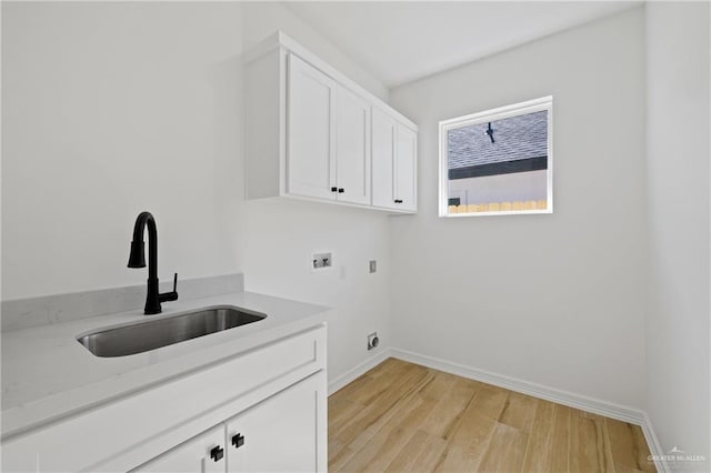 laundry area with cabinets, sink, light hardwood / wood-style floors, and hookup for a washing machine