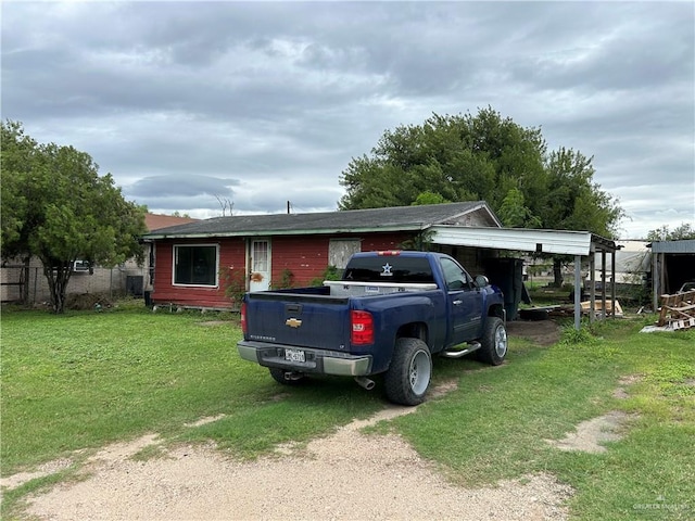 view of front of property featuring a front lawn and a carport