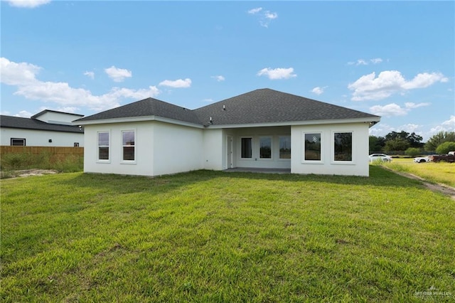 rear view of property featuring a lawn