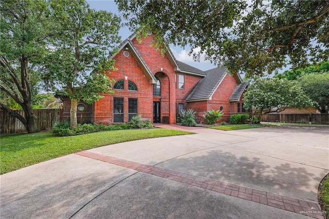 1900 E 2 Mile Line Rd, Mission, TX 78574 - traditional-style house with brick siding, fence, and a front yard