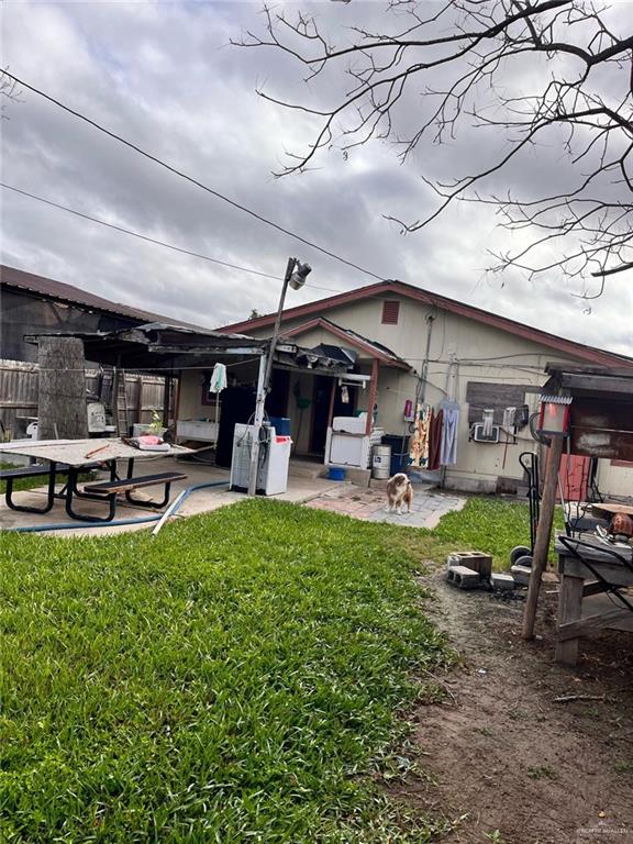 back of house featuring a patio and a lawn