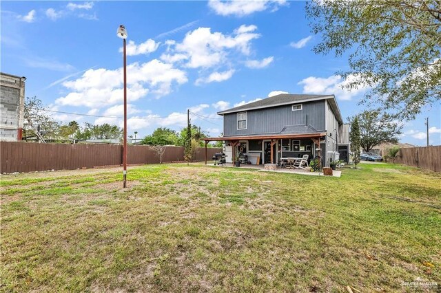 rear view of property with a lawn and a patio area