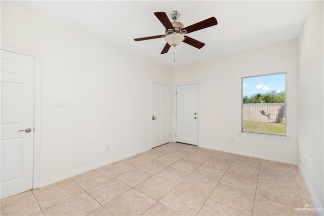 tiled spare room with ceiling fan