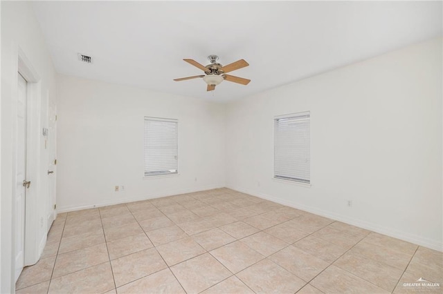 tiled empty room featuring ceiling fan