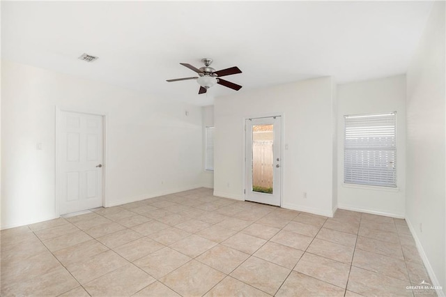 tiled empty room featuring ceiling fan