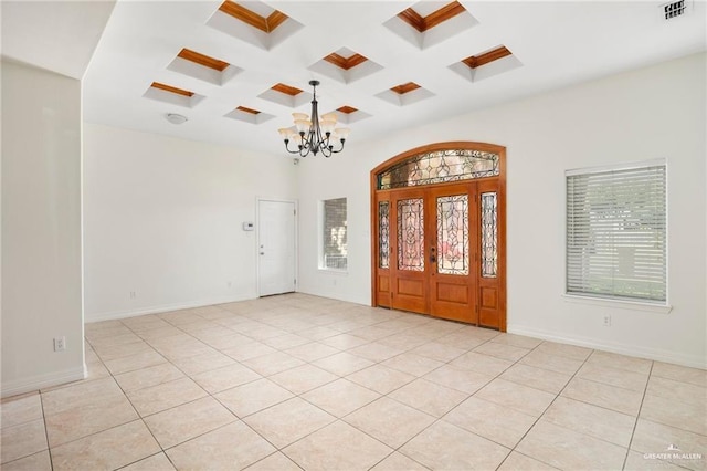 entryway featuring beamed ceiling, light tile patterned flooring, coffered ceiling, and an inviting chandelier