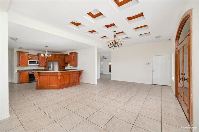 kitchen with appliances with stainless steel finishes, ceiling fan with notable chandelier, hanging light fixtures, light tile patterned floors, and kitchen peninsula