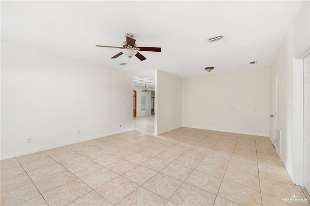 empty room featuring light tile patterned floors and ceiling fan with notable chandelier