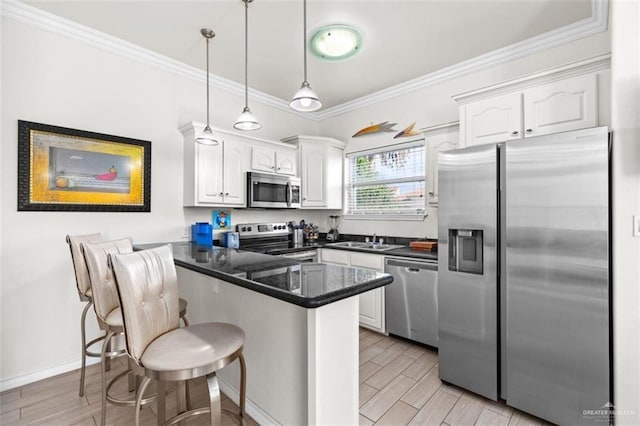 102 E Gardenia St, South Padre Island, TX 78597 - kitchen featuring white cabinets, stainless steel appliances, dark countertops, a sink, and a peninsula