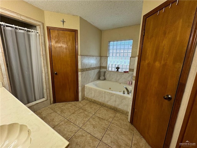 bathroom with tile patterned flooring, vanity, a textured ceiling, and independent shower and bath