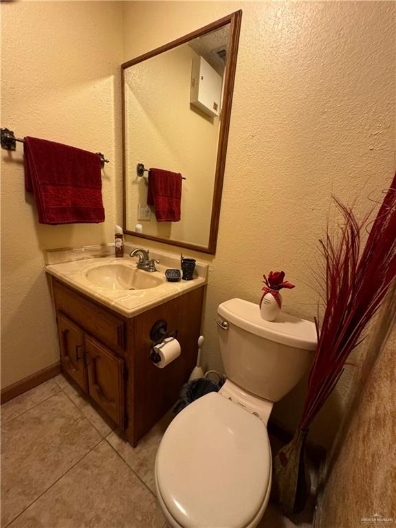 bathroom featuring tile patterned floors, vanity, and toilet