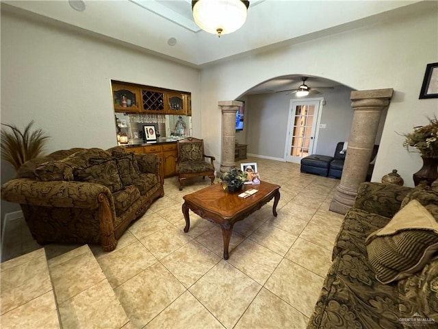 living room featuring bar area, ceiling fan, decorative columns, and light tile patterned floors