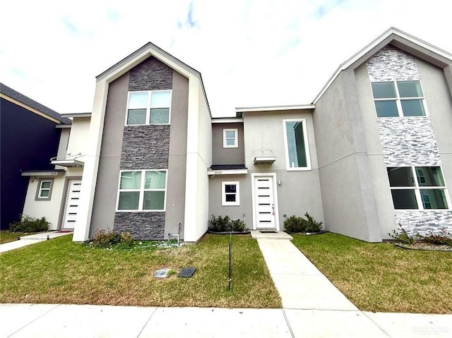 view of front of house featuring stone siding, a front lawn, and stucco siding