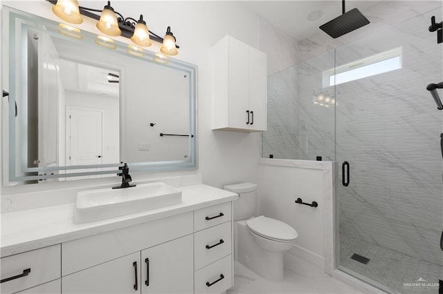 bathroom featuring a marble finish shower, marble finish floor, vanity, and toilet