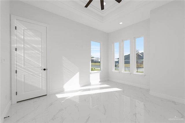 unfurnished room featuring marble finish floor, ceiling fan, a raised ceiling, baseboards, and recessed lighting