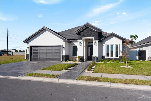 view of front facade with an attached garage, stone siding, a front yard, and stucco siding