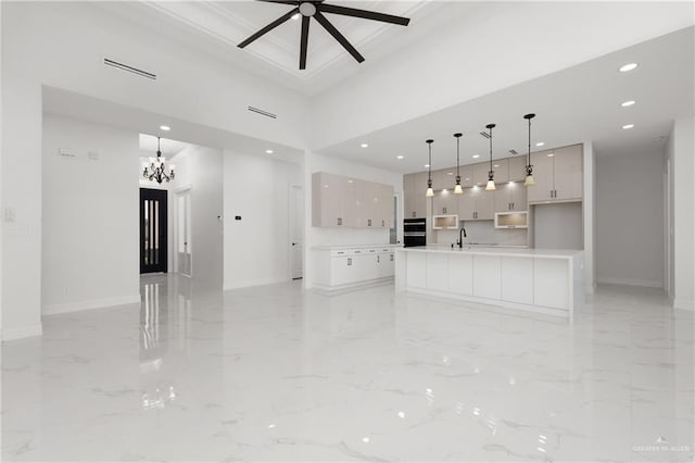 unfurnished living room with a sink, baseboards, recessed lighting, ceiling fan with notable chandelier, and marble finish floor