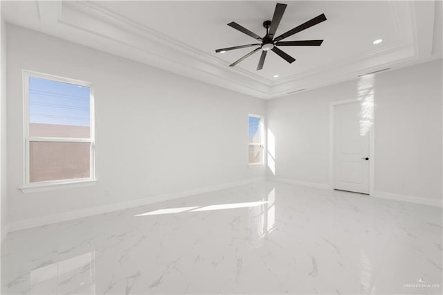 empty room featuring baseboards, a tray ceiling, recessed lighting, and marble finish floor