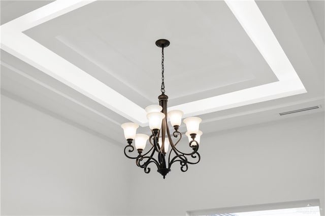room details with a chandelier, visible vents, and a raised ceiling
