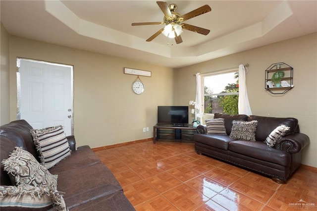 living room with parquet floors, a raised ceiling, and ceiling fan