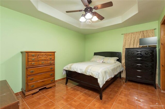 bedroom with a tray ceiling and ceiling fan