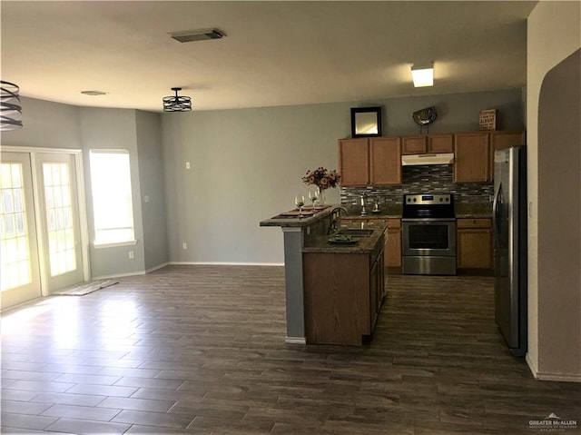 kitchen featuring sink, dark hardwood / wood-style flooring, backsplash, kitchen peninsula, and appliances with stainless steel finishes