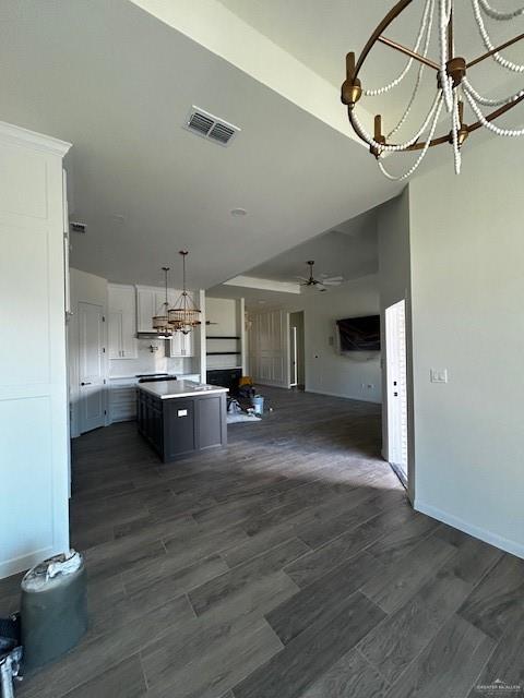 kitchen featuring a kitchen island, ventilation hood, white cabinetry, hanging light fixtures, and ceiling fan