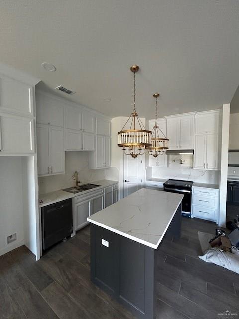 kitchen with sink, white cabinetry, range with electric stovetop, a kitchen island, and decorative light fixtures