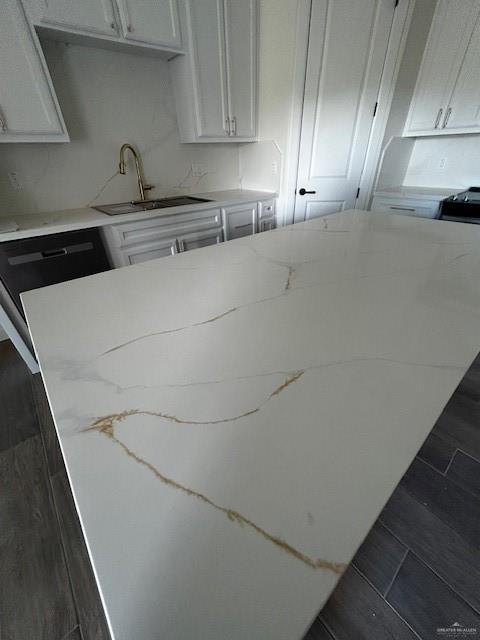 kitchen featuring light stone countertops, sink, and white cabinets