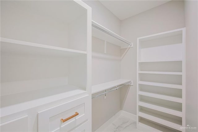 spacious closet featuring marble finish floor