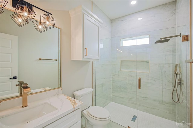 full bathroom featuring vanity, a shower stall, and toilet