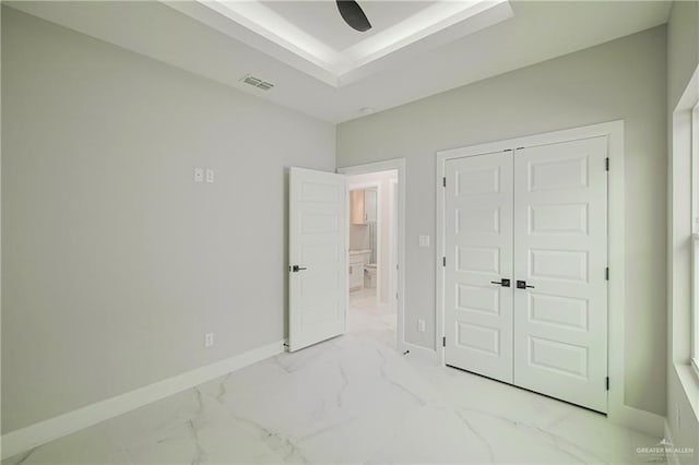 unfurnished bedroom featuring visible vents, baseboards, marble finish floor, a closet, and a raised ceiling