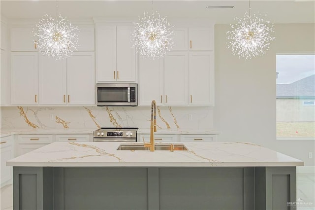 kitchen featuring an inviting chandelier, appliances with stainless steel finishes, and a sink