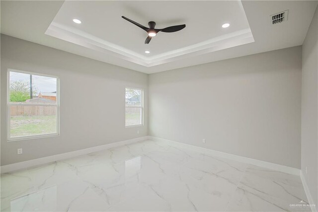 spare room featuring visible vents, a tray ceiling, and a wealth of natural light