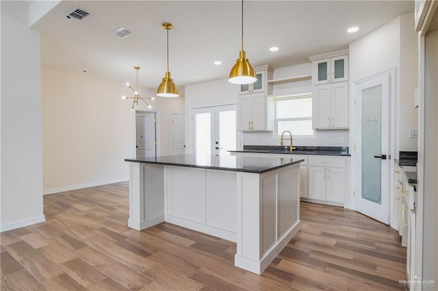 kitchen with dark countertops, visible vents, and light wood-style floors