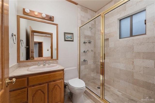 bathroom with vanity, a shower with shower door, and toilet