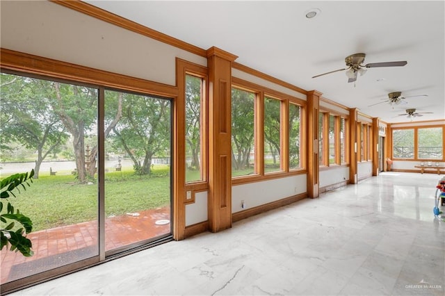 unfurnished sunroom with ceiling fan