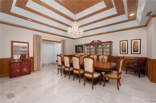 dining area with a notable chandelier, crown molding, and a tray ceiling