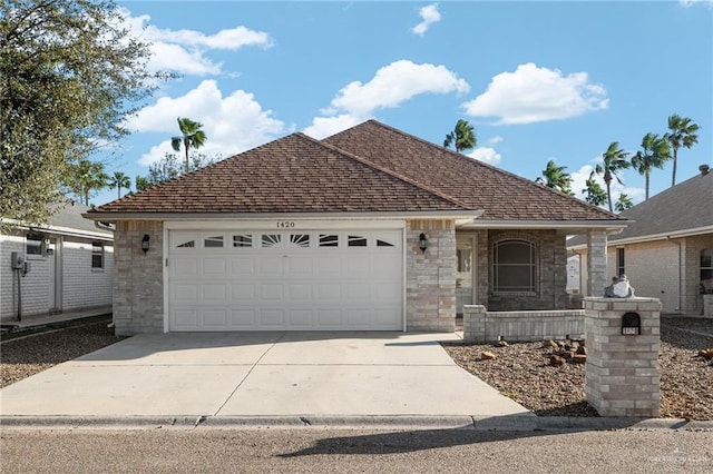 ranch-style house featuring driveway, stone siding, a shingled roof, and a garage